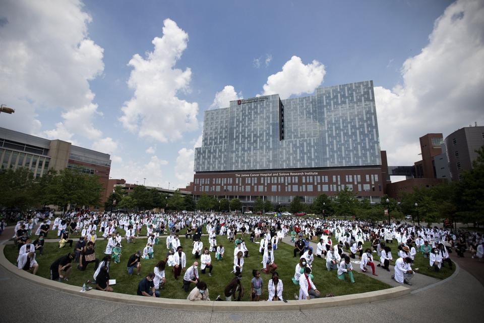 Doctors, nurses, medical students, and staff take a knee for eight minutes and 46 seconds, in front of the James Cancer Hospital, in solidarity with the Black Lives Matter movement, Friday, June 5, 2020.