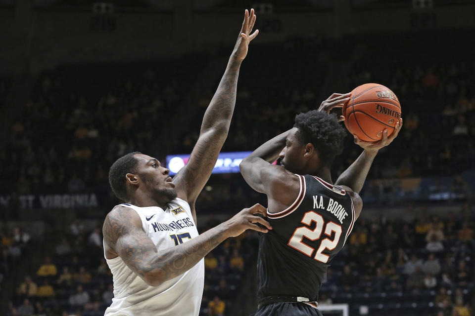 West Virginia forward Jimmy Bell Jr., left, defends against Oklahoma State forward Kalib Boone (22) during the first half of an NCAA college basketball game on Monday, Feb. 20, 2023, in Morgantown, W.Va. (AP Photo/Kathleen Batten)