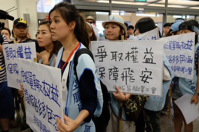 Flight attendants from the state-run China Airlines display placards reading "fight for labors' rights, guarantee the flight safety", during a demonstration at Sungshan airport in Taipei, on June 24, 2016