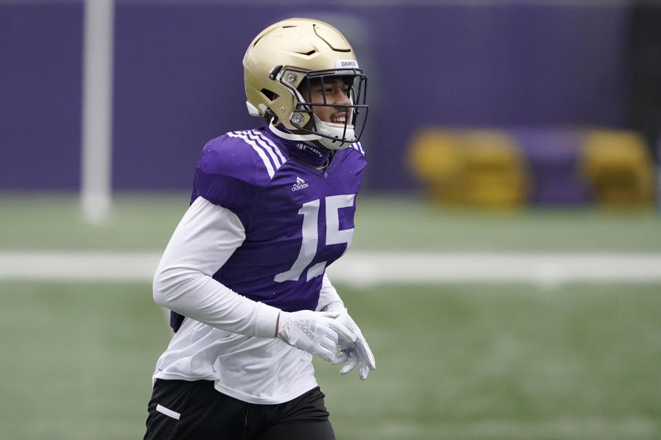 Washington linebacker Daniel Heimuli runs on the field at the start of NCAA college football practice, Friday, Oct. 16, 2020, in Seattle. (AP Photo/Ted S. Warren)