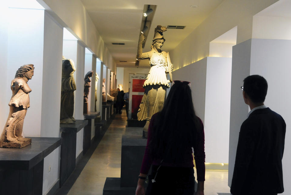 In this photo released by the Syrian official news agency, SANA, people attend the reopening ceremony for Syria's National Museum, in Damascus, Syria, Sunday, Oct. 28, 2018. Syrian officials, foreign archeologists and restoration specialists attended the Sunday reopening ceremony in the heart of Damascus more than six years after the prominent institution was shut down and emptied as the country's civil war encroached on the capital. (SANA via AP)