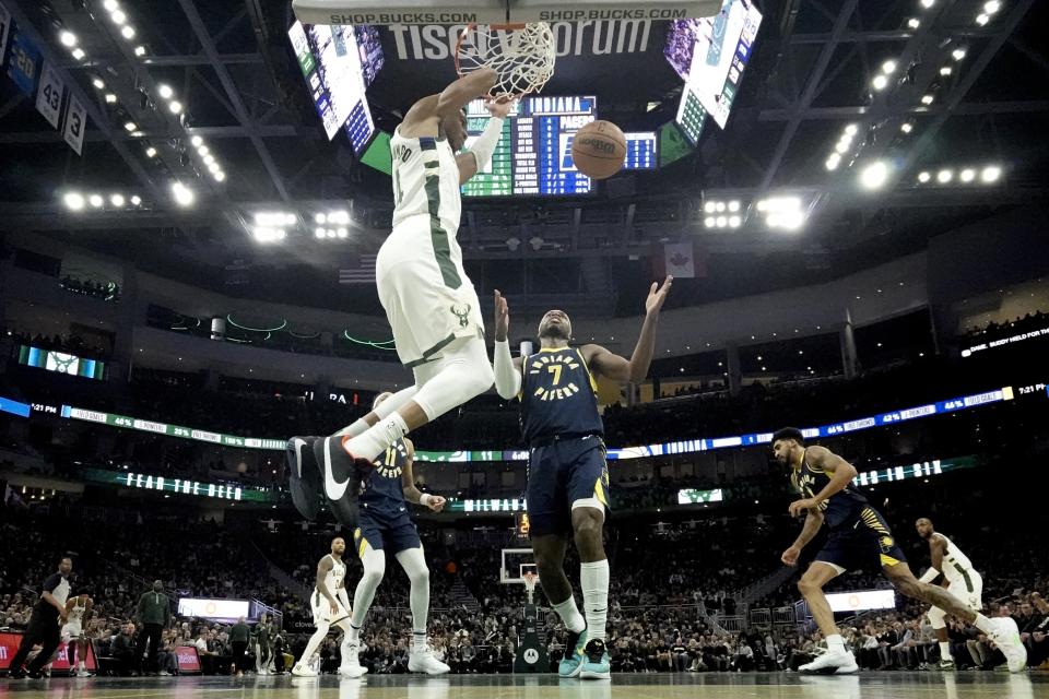 Milwaukee Bucks' Giannis Antetokounmpo dunks over Indiana Pacers' Buddy Hield during the first half of an NBA basketball game Wednesday, Dec. 13, 2023, in Milwaukee. (AP Photo/Morry Gash)