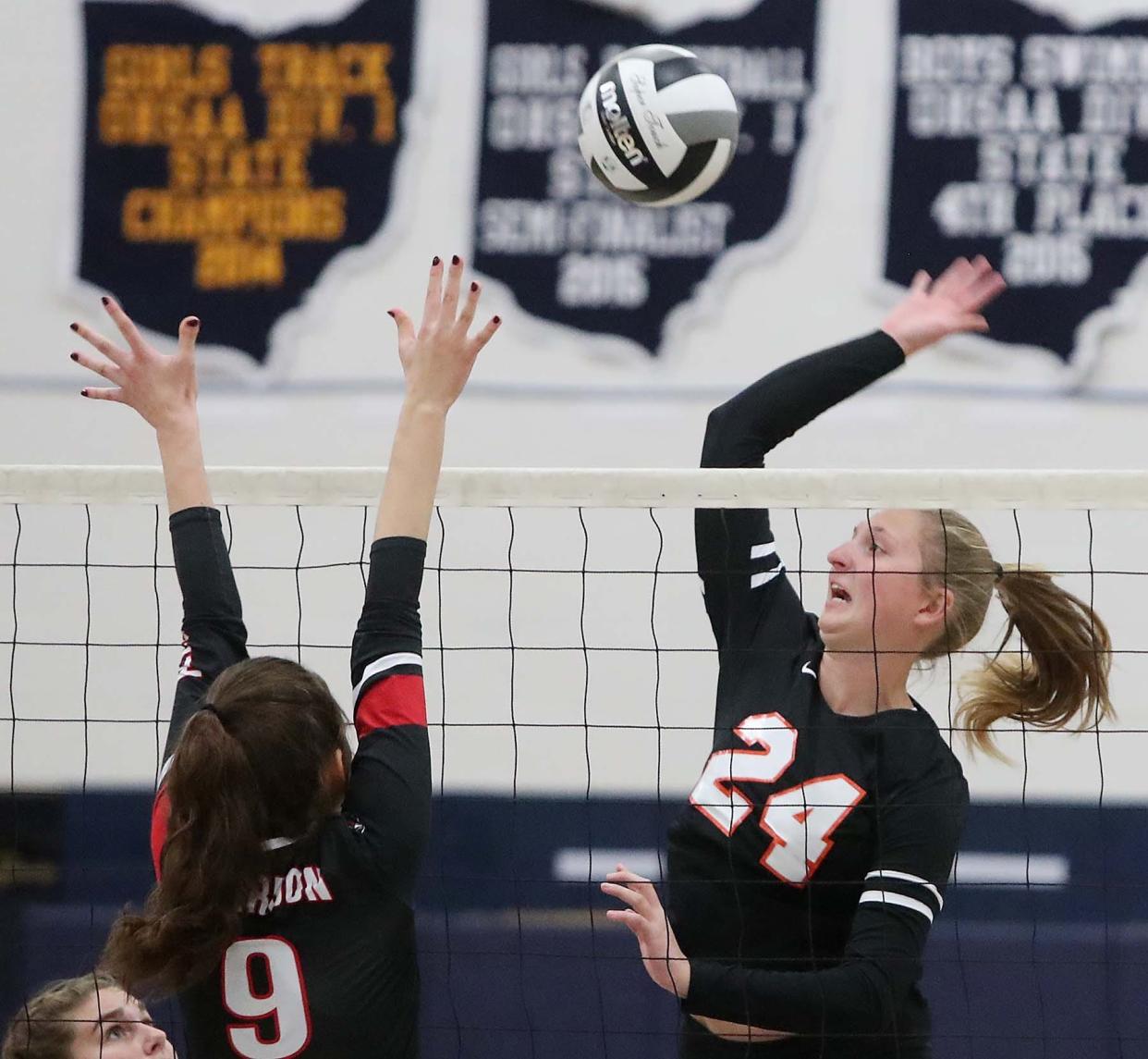 Kassidy Gorsuch, right, of Green slams the ball over the net for a point past Natalie Zemba of Chardon during first set of their Division I volleyball district semifinal match at Solon High School in Solon on Tuesday night. Chardon advanced in tournament 3-1.