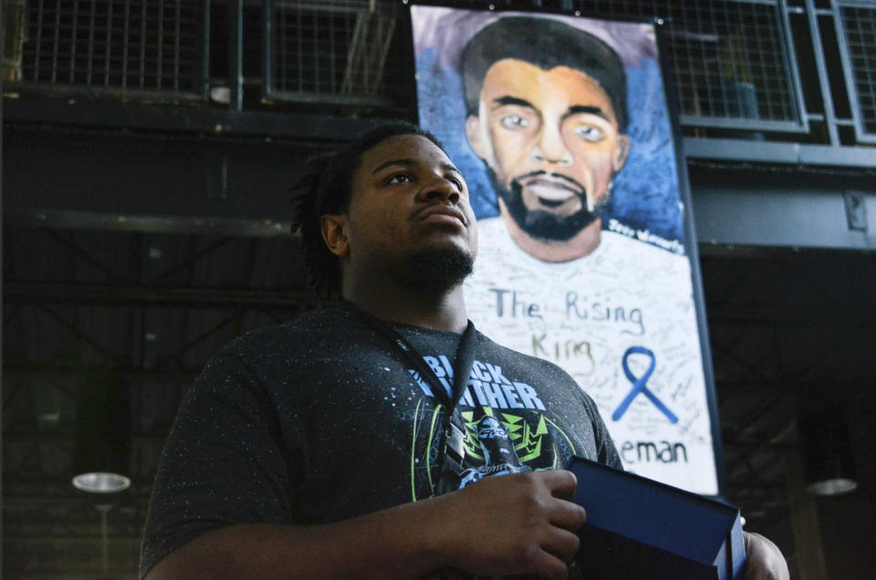 South Carolina artist, Joey Withinarts, stands in front of portraits of Chadwick Boseman dressed as the Black Panther on Thursday, Oct. 22, 2020 in Anderson, S.C. Withinarts started painting his portrait of the hometown star just hours after he heard of his passing in August. (Charles McBryde, Via AP)
