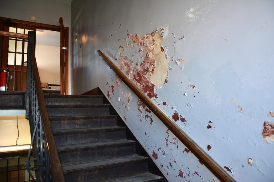 The stairwell to the second floor shows peeling paint.