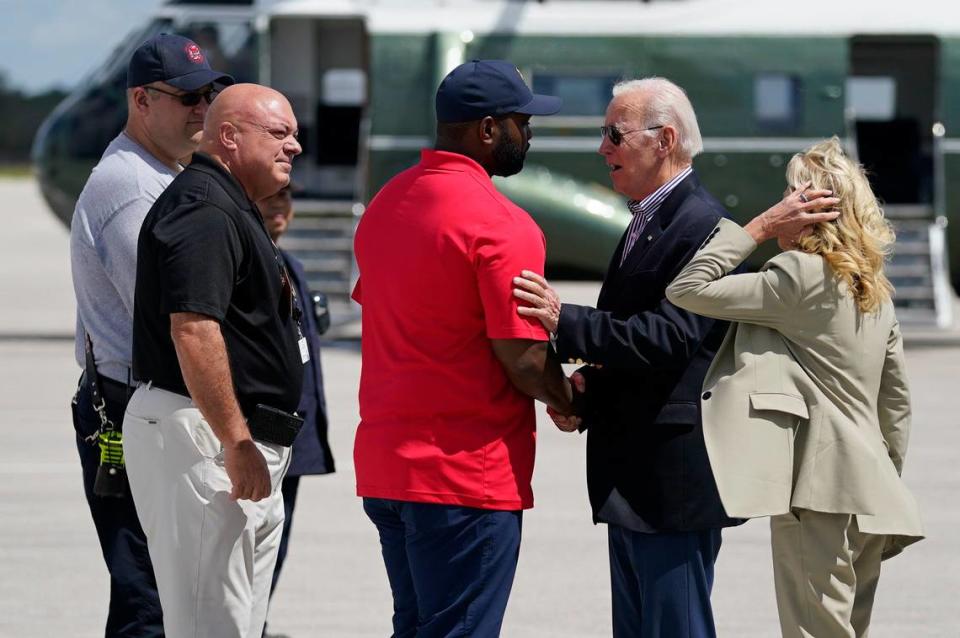 President Joe Biden shakes hands with Rep. Byron Donalds, R-Fla., center, as he and first lady Jill Biden are greeted after arriving at Southwest Florida International Airport to visit areas impacted by Hurricane Ian, Wednesday, Oct. 5, 2022, in Fort Myers, Florida. Lee County Chairman Cecil Pendergrass, second from left, looks on.