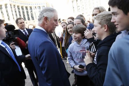 Britain's Prince Charles (C), Prince of Wales, asks schoolboys about their favorite sports as he departs the National Archives in Washington, March 18, 2015. REUTERS/Jonathan Ernst