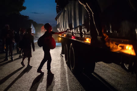 A migrant, traveling with a caravan of thousands from Central America en route to the United States, looks to hitch a ride on a truck to Arriaga from Pijijiapan, Mexico October 26, 2018. REUTERS/Adrees Latif