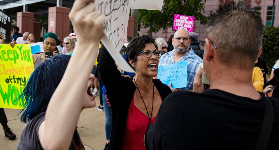 Pro-choice protesters, Jaime Renee Cruz, center, and Addyson Ryan left, have a heated conversation with anti abortion protester Tom Cabral during a protest in downtown Fort Myers on Tuesday. Supporters and opponents of abortion rights were present. Members for abortion rights held the protest in response to a leaked draft opinion from the Supreme Court seeking to overturn Roe v. Wade.