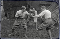 <p>Lancashire-born boxer Arthur Vanderstock (left), who served with the Australian 1st Division Signal Company, pretends to be mid-box with another man in a farmyard. The soldier ‘refereeing’ is wearing the cap badge of the Royal Artillery. (Courtesy Kerry Stokes Collection, The Louis and Antoinette Thuillier Collection) </p>