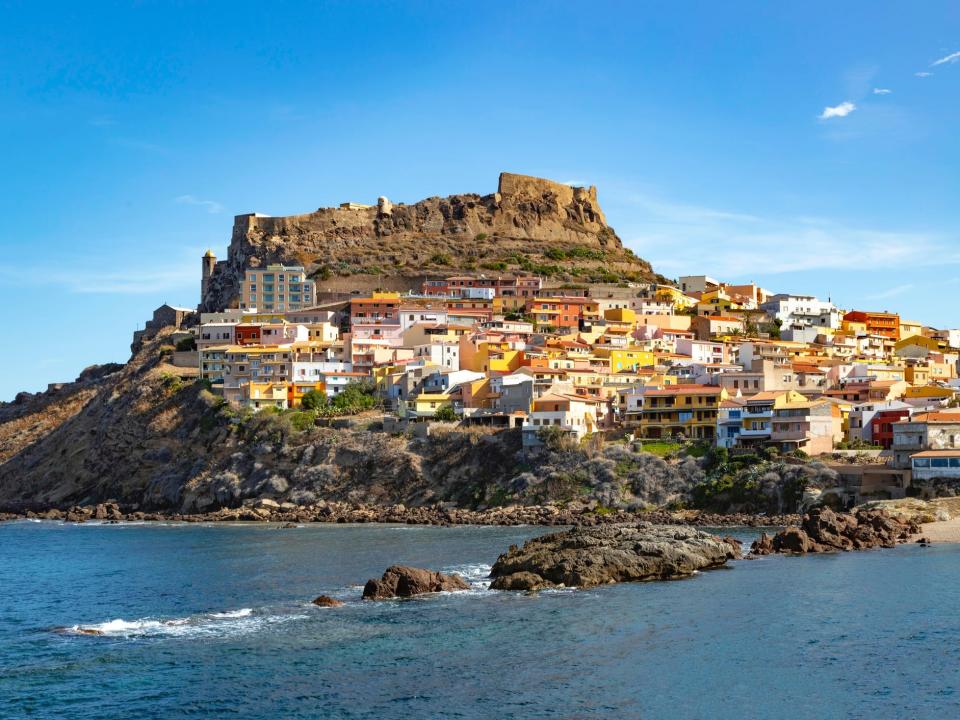 A colourful town on the coast of Sardinia on a big hill