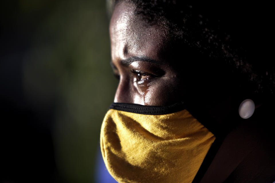 A family member wearing a face mask cries during Kathlen Romeu's funeral.