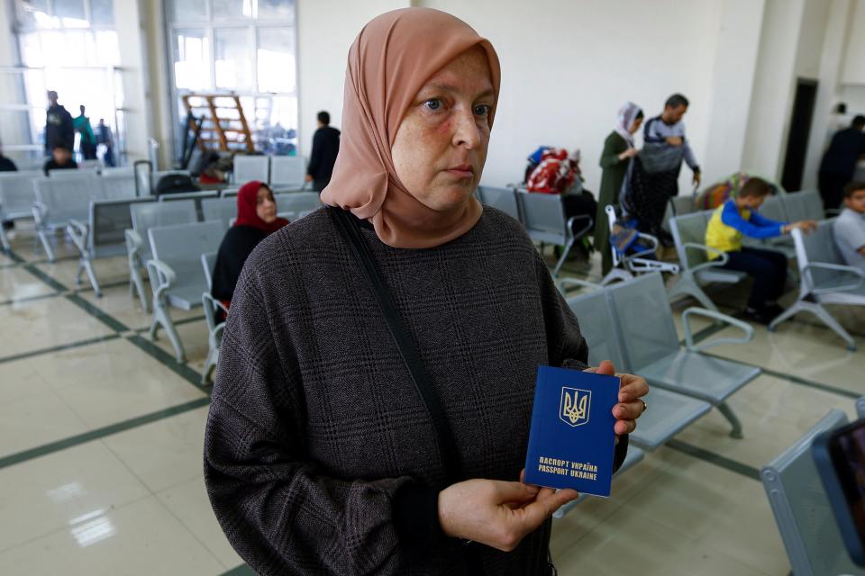 Ukrainian woman Tatyana Tapalova displays her passport as she waits for an opportunity to escape Gaza (REUTERS)