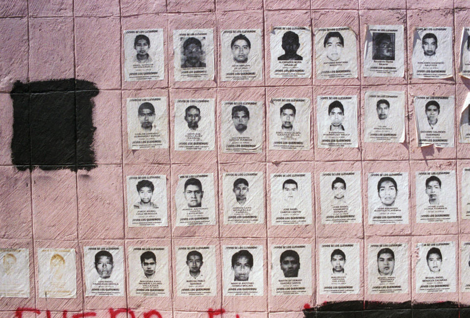 Posters of the 43 missing students cover the base of a statue in Chilpancingo, Guerrero, on March 5, 2015.