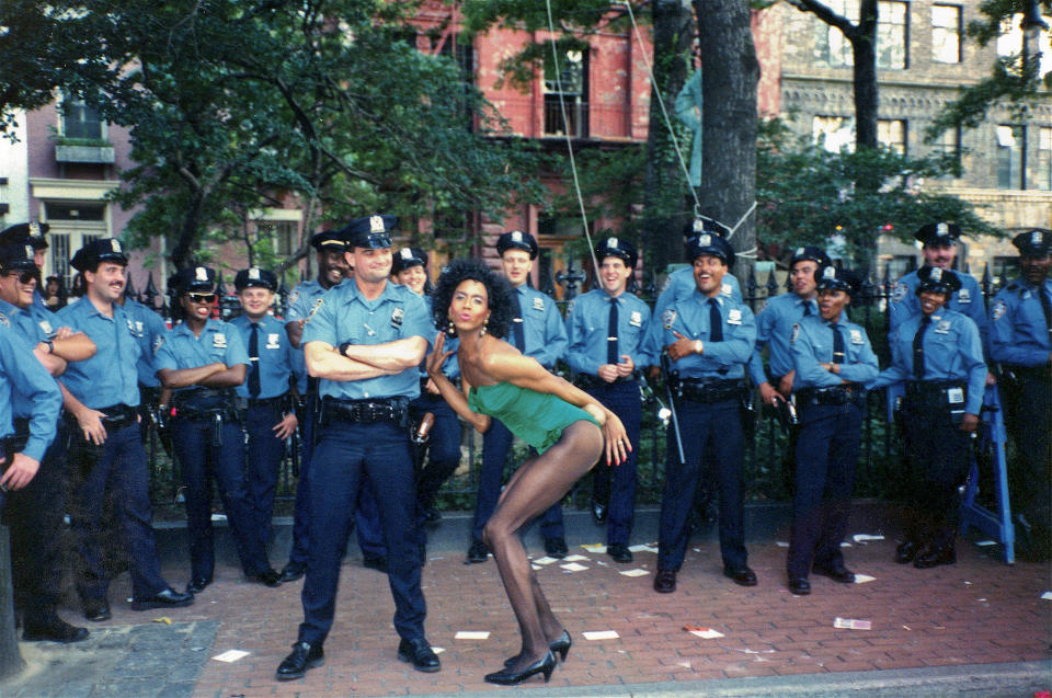 In this June 24, 1990, photo provided by Thomas Garguilo, Darryl Brantley, a waiter at New Jimmy's, poses with New York Police Department officers while dressed in a Playboy bunny outfit as they await the Pride parade to make its way past the bar. New Jimmy's was a bar that was created and opened in 1990 in the space of the original Stonewall Inn, which went out of business shortly after the riots in 1969. (Thomas Garguilo via AP)