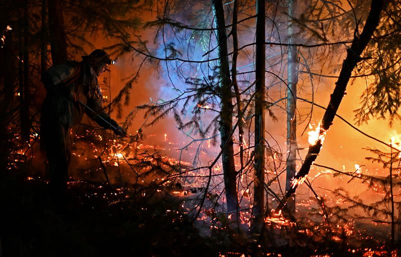 FILE PHOTO: A volunteer works to extinguish a wildfire near Revda