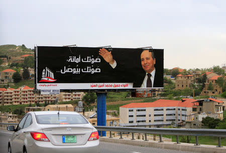 A car drives past a campaign poster for Jamil al-Sayyed at Dahr al-Baidar area in Lebanon's eastern Bekaa Valley, Lebanon April 25, 2018. REUTERS/Ali Hashisho