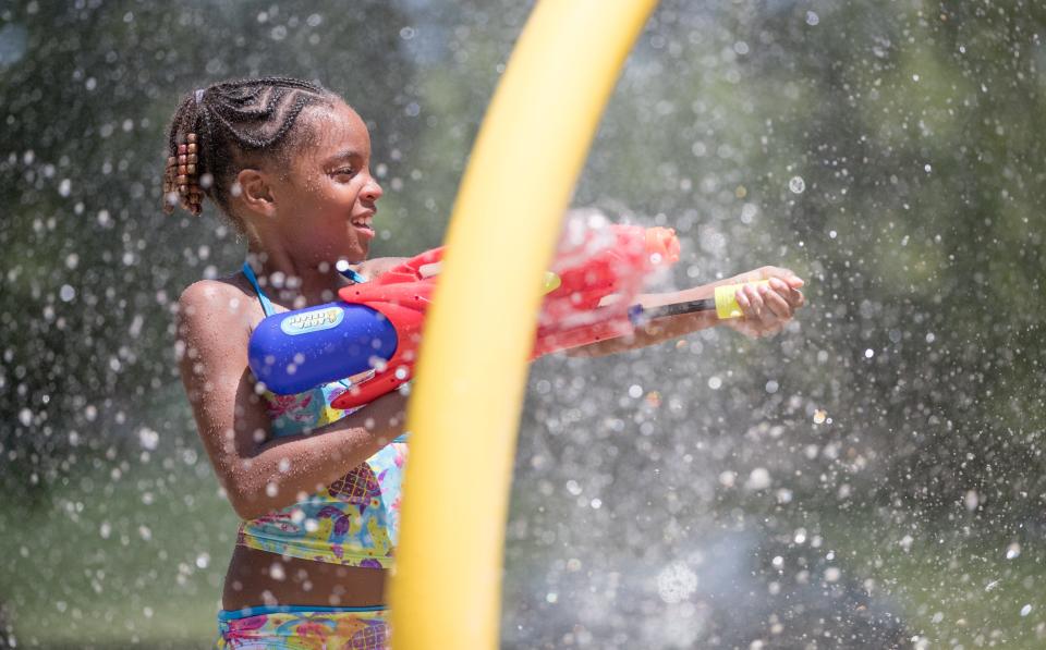 Alaiah Walliams sprays her friend with a water gun at  Bertha Ross Park splash pad in Indianapolis on Thursday, June 28, 2018. 