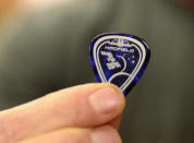 Chris Hadfield displays his custom guitar pick that he used when performing the first original song to ever be recorded aboard the International Space Station.