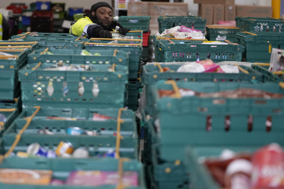 A volunteer from the charity 'The Felix Project' collects food at their storage hub in London, Wednesday, May 4, 2022. Across Britain, food banks and community food hubs that helped struggling families, older people and the homeless during the pandemic are now seeing soaring demand. The cost of food and fuel in the U.K. has risen sharply since late last year, with inflation reaching the highest level in 40 years. (AP Photo/Frank Augstein)