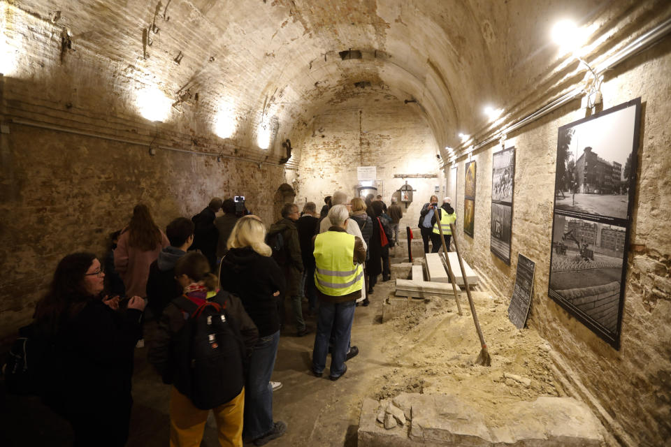 People line up to see an escape tunnel, underneath the Berlin Wall which divided the city for 28 years during the Cold War, and was make visible for public for the first time, in Berlin, Germany, Thursday, Nov. 7, 2019.The tunnel was built by a group of people who had escaped earlier from communist East Germany to West Berlin. They wanted to help friends and family to flee to the West, too, but days before it was finished, East German officials discovered and destroyed it. (AP Photo/Markus Schreiber)