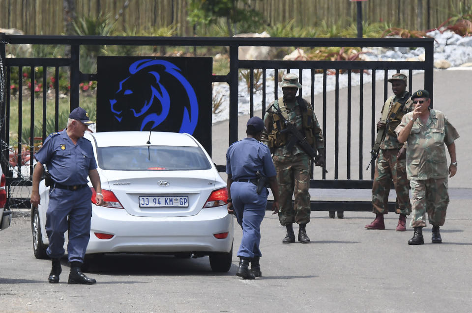 Soldiers and police guard the entrance, Friday, March 13, 2020, to the venue where repatriated South Africans from Wuhan China will be held in quarantine near Polokwane, South Africa. For most people the new coronavirus causes only mild or moderate symptoms, such as fever and cough. For some, especially older adults and people with existing health problems, it can cause more severe illness, including pneumonia. (AP Photo)
