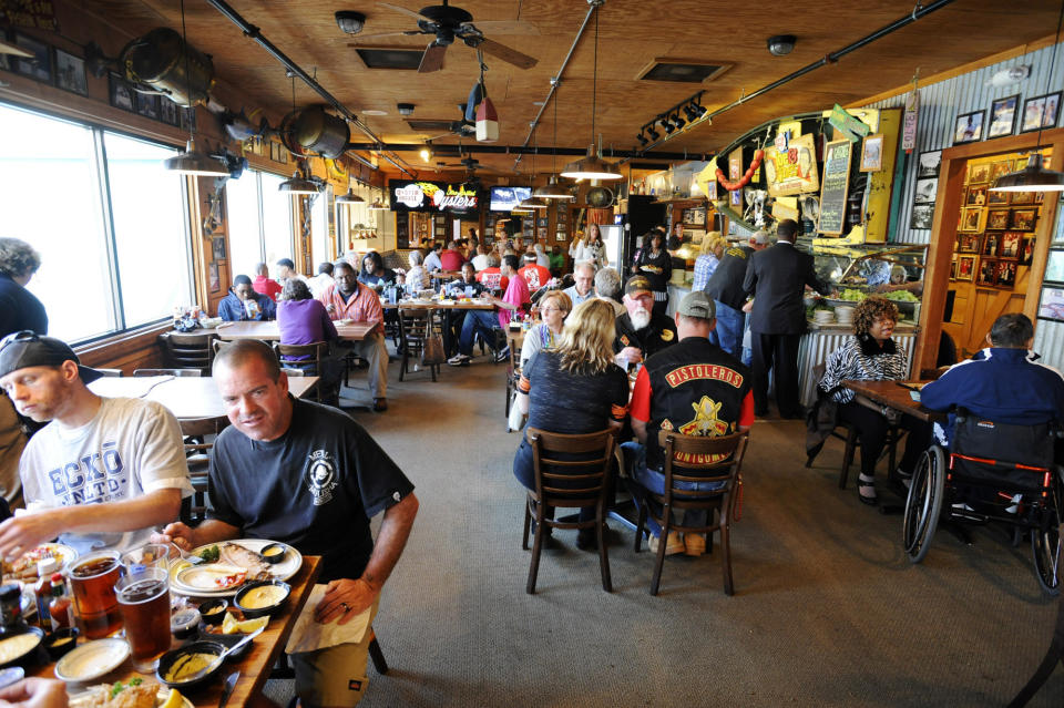 This March 1, 2014 photo shows diners in the Original Oyster House in Spanish Fort, Ala. The business is one of more than a half-dozen restaurants on "Seafood Row," located on a parkway across the Mobile Delta at Mobile, Ala. Many locals know the area for family-style seafood, but visitors sometimes have a difficult time finding it. (AP Photo/Jay Reeves)