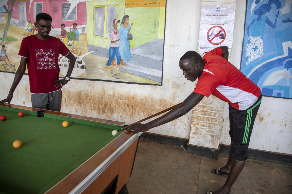 Peter Nyuoni, right, from Sudan, who was evacuated from Libya to Rwanda, plays pool with others at the Gashora transit center for refugees and asylum-seekers, in the Bugesera district of Rwanda Friday, June 10, 2022. As Britain plans to send its first group of asylum-seekers to Rwanda amid outcries and legal challenges, some who came there from Libya under earlier arrangements with the United Nations say the new arrivals can expect a difficult time ahead. (AP Photo)