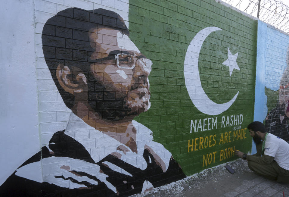 A student gives finishing touches to a mural paying tribute to Naeem Rashid, a Pakistani citizen who was killed in the Christchurch mosque shootings, at a school in Lahore, Pakistan, Sunday, March 24, 2019. Rashid along with his son and 48 others were killed in a terror attack at two mosques in New Zealand, on March 15. (AP Photo/K.M. Chaudary)