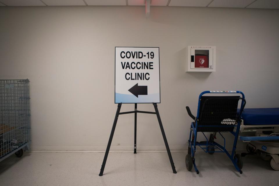  A sign points to a COVID-19 vaccination clinic at Bayhealth's Kent County campus Tuesday, Dec. 15, 2020, in Dover. 