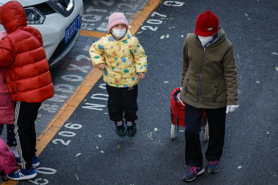 A child wears a face mask after dismissal from a school in Beijing, China, 23 November 2023. 