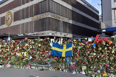 Flowers are seen on a fence by Ahlens department store following Friday's attack in central Stockholm, Sweden, April 9, 2017. According to local media, the flowers were moved to the steps at Sergels Torg on Sunday morning. TT News Agency/Jonas Ekstromer/via REUTERS