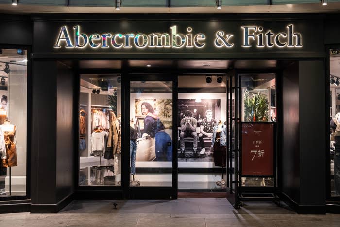 Storefront of Abercrombie & Fitch with illuminated sign and displayed fashion posters