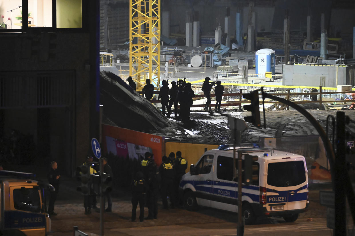 Police officers in special equipment stand next to a Jehovah's Witness building in Hamburg, Germany, Thursday, March 9, 2023. German police say shots were fired inside a building used by Jehovah’s Witnesses in Hamburg and an unspecified number of people were killed or wounded. (Jonas Walzberg/dpa via AP)