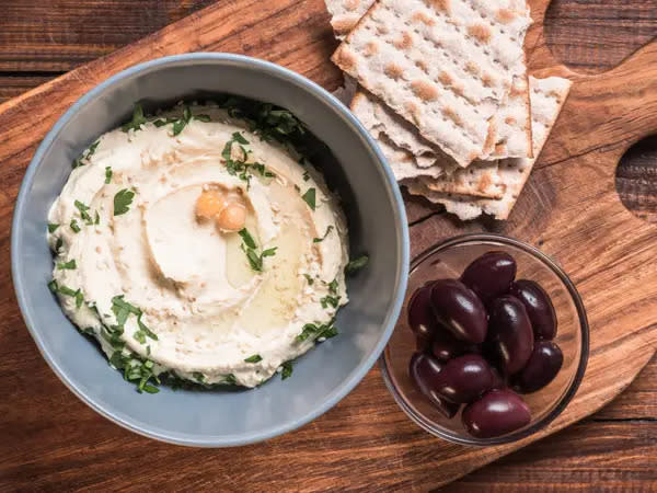 Das Snackbrett kann Hummus, Oliven und Cracker enthalten. - Copyright: Shutterstock