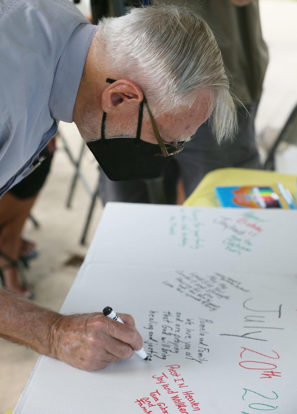 The Rev. John Beaty, a retired United Methodist pastor, signs a birthday card for Jayland Walker on July 20, which would have been Walker's 26th birthday.