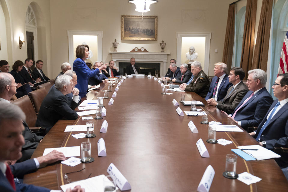 In this photo released by the White House, President Donald Trump, center right, meets with House Speaker Nancy Pelosi, standing left, Congressional leadership and others, Wednesday, Oct. 16, 2019, in the Cabinet Room of the White House in Washington. Trump and Pelosi have not spoken in five months at a time when the nation is battling its worst health crisis in a century. (Official White House Photo by Shealah Craighead via AP)