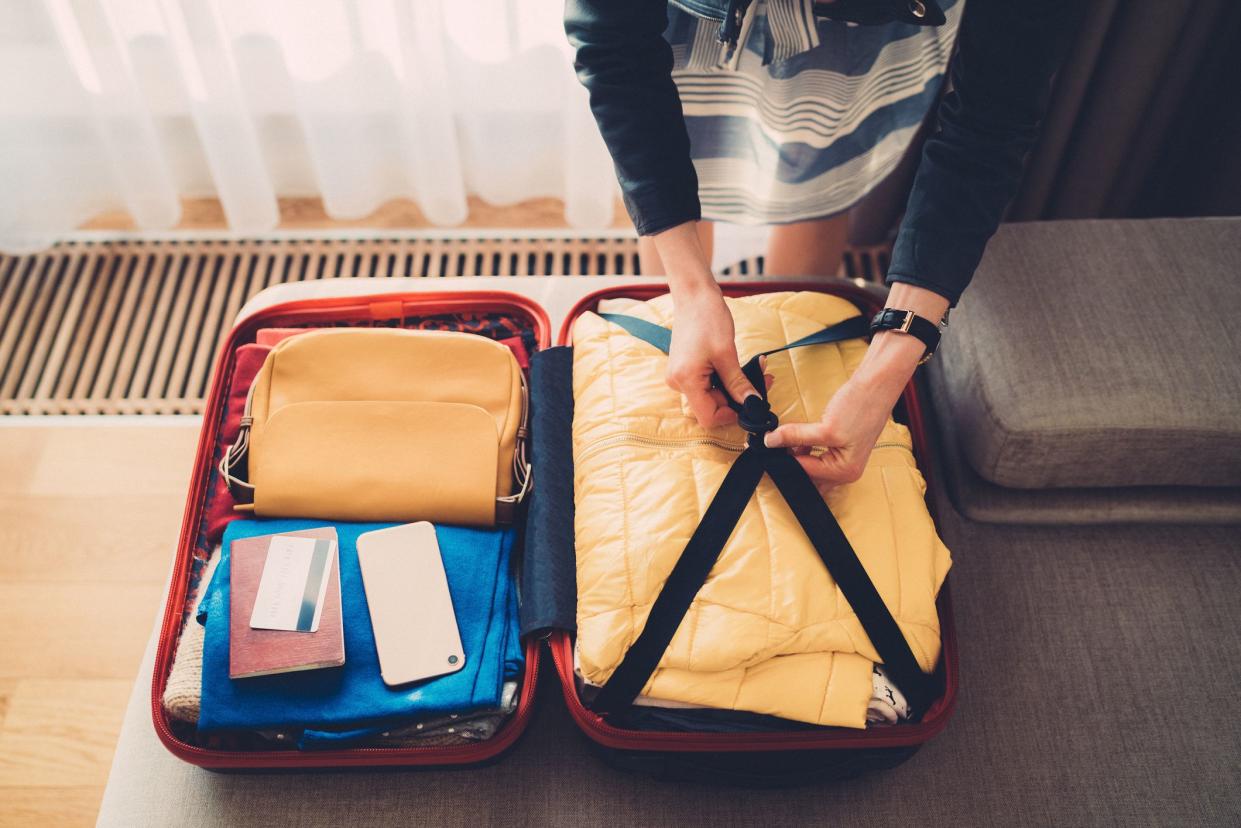 Close-up of woman preparing luggage