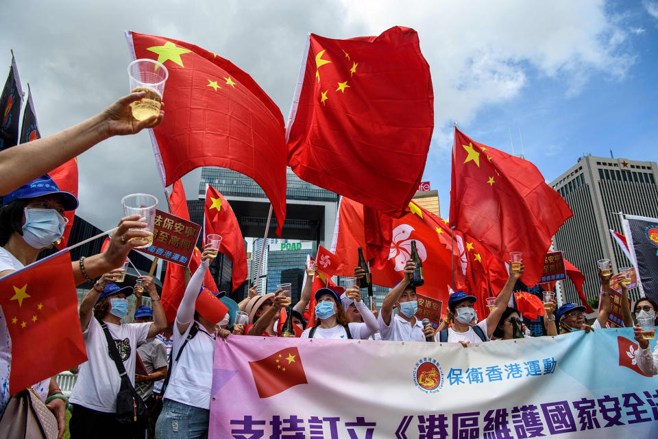 Image: Pro-China supporters display Chinese and Hong Kong flags as they raise a toast with champagne during a rally near the government headquarters in Hong Kong (Anthony Wallace / AFP - Getty Images)