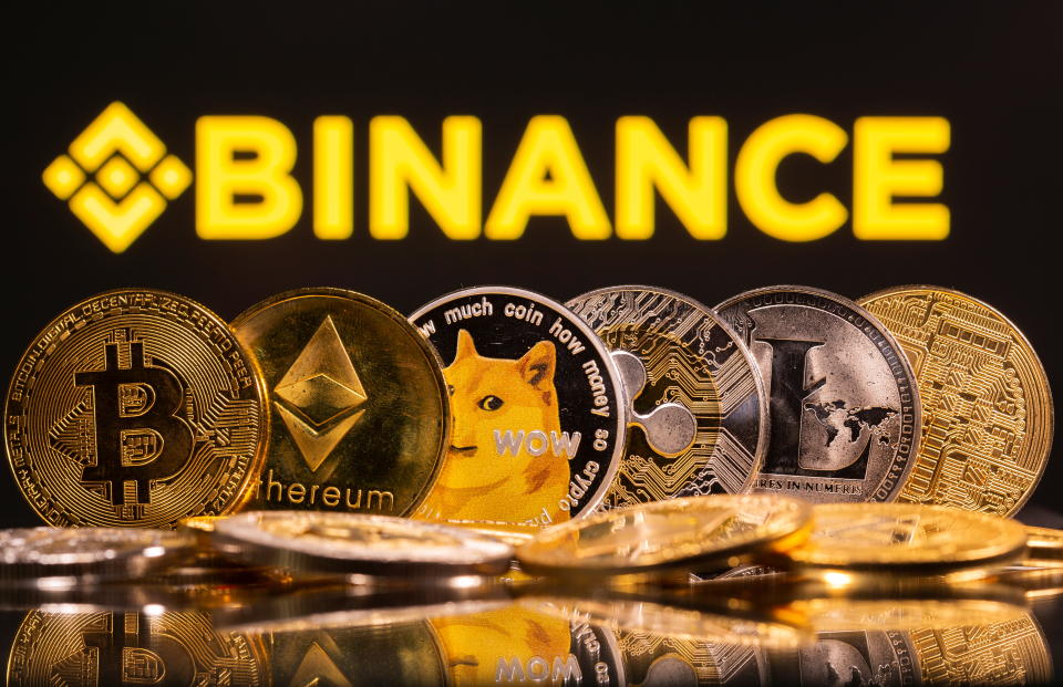 Representations of cryptocurrencies Bitcoin, Ethereum, DogeCoin, Ripple, and Litecoin are seen in front of a displayed Binance logo in this illustration taken, June 28, 2021. REUTERS/Dado Ruvic/Illustration