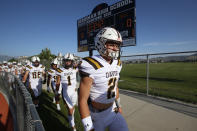 Davis players walk off the field before the start of their high school football game against Herriman on Thursday, Aug. 13, 2020, in Herriman, Utah. Utah is among the states going forward with high school football this fall despite concerns about the ongoing COVID-19 pandemic that led other states and many college football conferences to postpone games in hopes of instead playing in the spring. (AP Photo/Rick Bowmer)