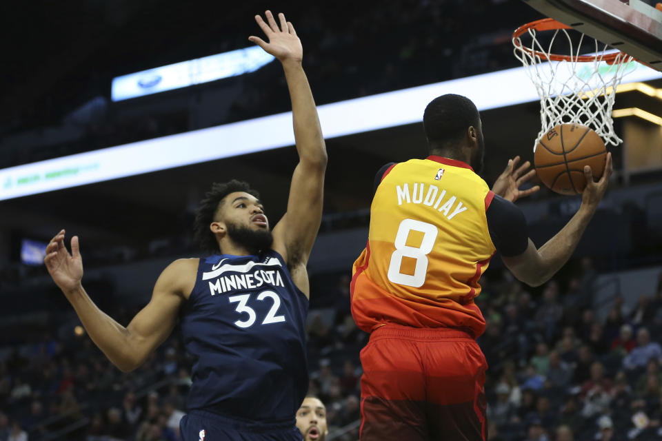 Utah Jazz's Emmanuel Mudiay goes up to the basket against Minnesota Timberwolves' Karl-Anthony Towns in the first half of an NBA basketball game Wednesday, Dec. 11, 2019, in Minneapolis. (AP Photo/Stacy Bengs)