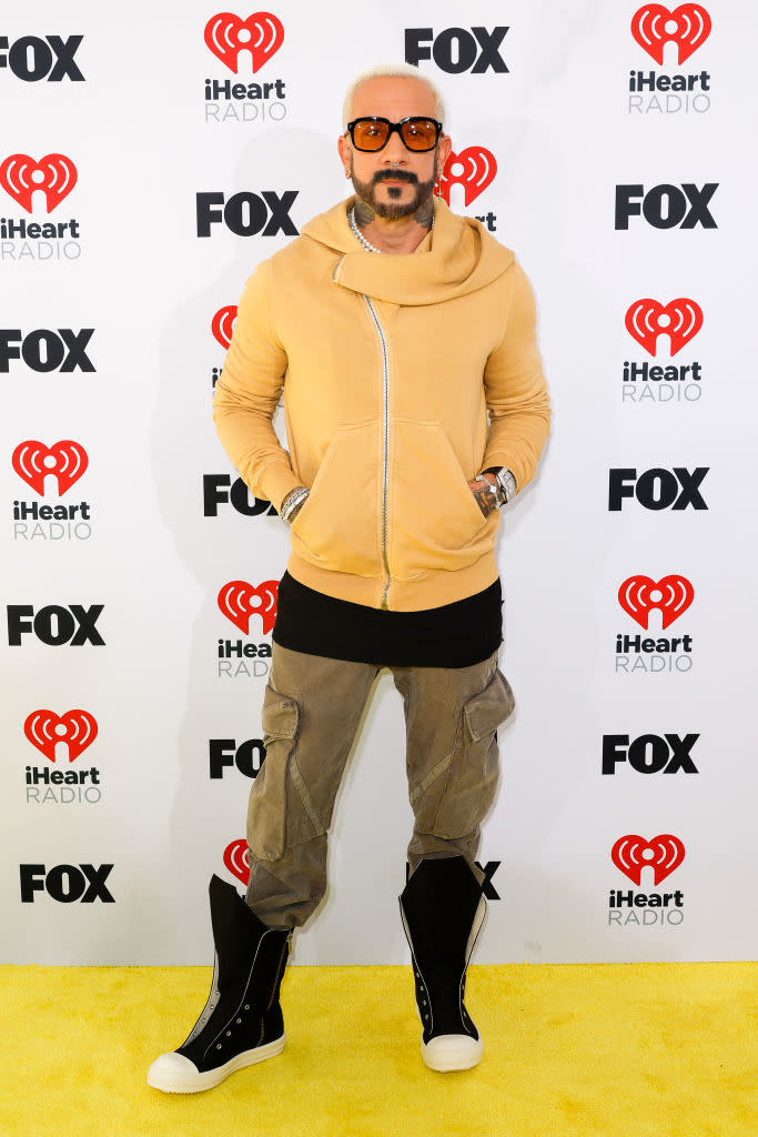 AJ McLean in a hooded sweatshirt, cargo pants, and boots posing at an iHeartRadio event