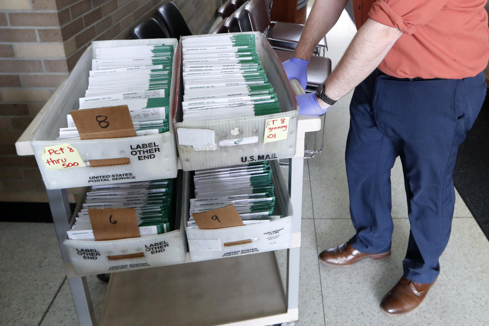 FILE — Absentee ballots to be counted are moved at City Hall in Garden City, Mich., on May 5, 2020. A total of 1.6 million people have requested absentee ballots so far this year, surpassing the 1.16 million who chose the option in the 2018 midterm election. (AP Photo/Paul Sancya, File)