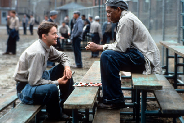 Tim Robbins and Morgan Freeman sitting outside on the benches playing checkers and talking in a scene from the film ‘The Shawshank Redemption’, 1994. (Photo by Castle Rock Entertainment/Getty Images)
