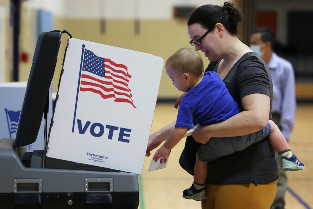 A voter and her child cast a ballot during the midterm primary elections in Virginia in June 2022. <a href="https://media.gettyimages.com/photos/voter-casts-her-ballot-with-her-child-at-a-polling-station-at-rose-picture-id1404219726" rel="nofollow noopener" target="_blank" data-ylk="slk:Alex Wong/Getty Images;elm:context_link;itc:0;sec:content-canvas" class="link ">Alex Wong/Getty Images</a>