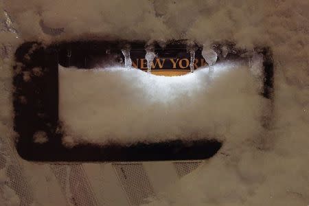 A license plate is obscured by snow and ice in the Manhattan borough of New York, January 23, 2016. REUTERS/Carlo Allegri