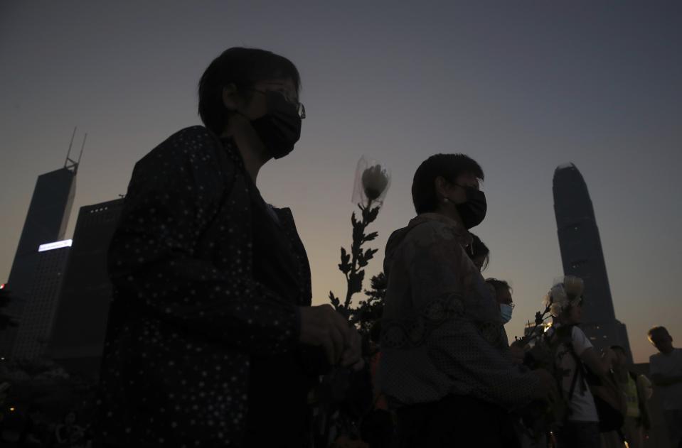 People attend a vigil for student Chow Tsz-Lok in Hong Kong, Saturday, Nov. 9, 2019. Chow Tsz-Lok, the Hong Kong university student who fell off a parking garage after police fired tear gas during clashes with anti-government protesters died Friday in a rare fatality in five months of unrest, fueling more outrage against authorities in the semi-autonomous Chinese territory. (AP Photo/Kin Cheung)