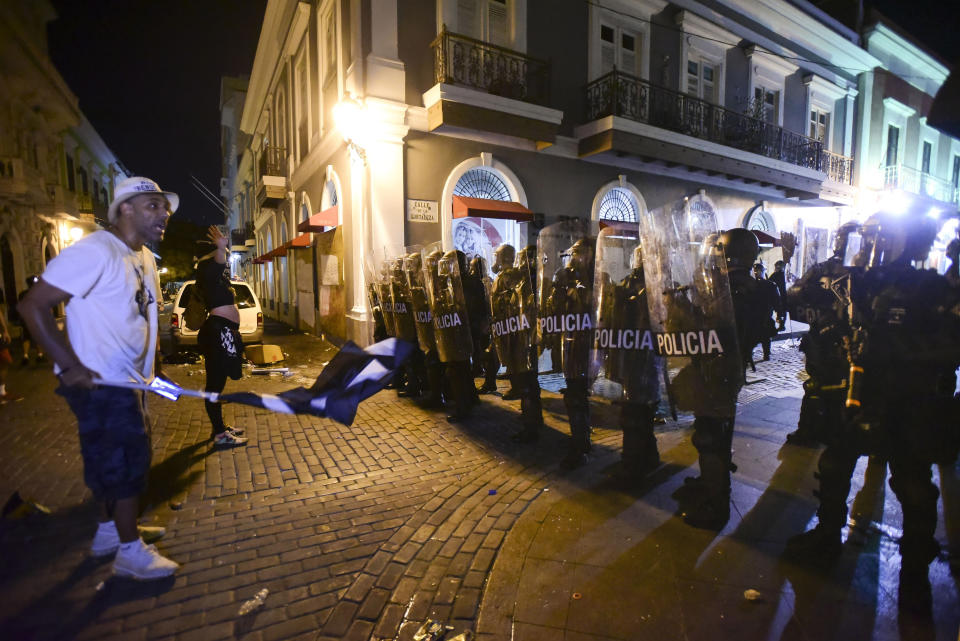 Demonstrators stand in front of riot control units during clashes in San Juan, Puerto Rico, Monday, July 22, 2019. Protesters are demanding Gov. Ricardo Rossello step down following the leak of an offensive, obscenity-laden online chat between him and his advisers that triggered the crisis. (AP Photo / Carlos Giusti)