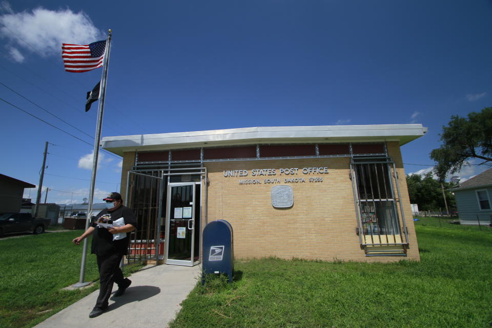 The post office in Mission, S.D. saw a steady flow of people on Aug. 6, 2020. The post office is one of four on the roughly 2,000 square miles (5,180 square kilometers) of the Rosebud Indian Reservation (AP Photo/Stephen Groves)